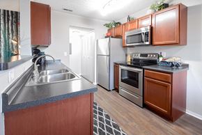 Reynoldsburg townhouse for rent - a kitchen with stainless steel appliances and wooden cabinets