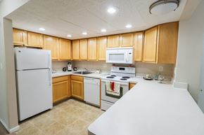 Galloway apartment for rent - a kitchen with white appliances and wooden cabinets