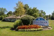 Galloway apartment for rent - the sign for stoneybrook in front of a garden with colorful flowers