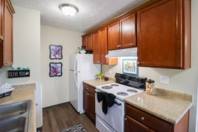 Reynoldsburg townhouse for rent - A kitchen with a white refrigerator and a white stove.