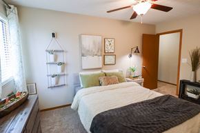 Reynoldsburg townhouse for rent - A bedroom with a bed, a window, and a ceiling fan.