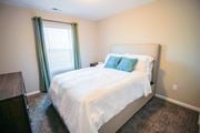 Canal Winchester apartment for rent - a bedroom with white bedding and green pillows