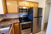 Grove City townhouse for rent - a kitchen with stainless steel appliances and wooden cabinets