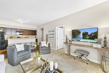 Hilliard apartment for rent - A living room with a grey couch, a coffee table, and a television on a wooden stand.