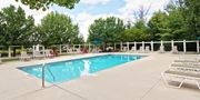 Reynoldsburg townhouse for rent - A large swimming pool surrounded by lounge chairs and trees.