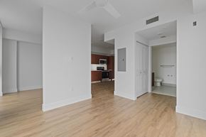 Opa Locka apartment for rent - A room with white walls and wooden flooring with a doorway leading to another room.