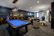 Atlanta apartment for rent - A blue pool table is in the middle of a room with a city skyline on the wall.