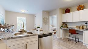 Atlanta apartment for rent - A kitchen with a sink, dishwasher, and a counter with a chair.