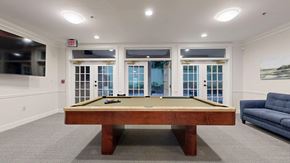 Atlanta apartment for rent - A pool table in a room with a couch and a window.