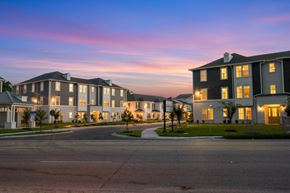 Baton Rouge apartment for rent - A large, well-lit building complex with multiple structures and a clear sky above.