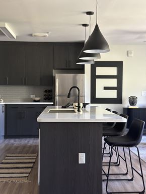 Atlanta apartment for rent - A modern kitchen with a dark wood island and chairs.