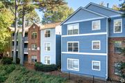 Atlanta apartment for rent - A blue building with white windows is situated next to a green building with red brick.