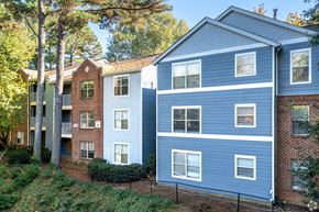 Atlanta apartment for rent - A blue building with white windows is situated next to a green building with red brick.