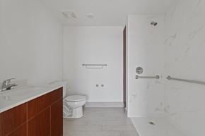 Opa Locka apartment for rent - A white bathroom with a toilet, sink, and shower.