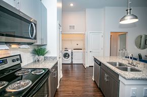 Atlanta apartment for rent - A modern kitchen with a black stove top oven and a white microwave above it.