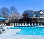 Atlanta apartment for rent - A swimming pool in front of a house with a fence and trees in the background.