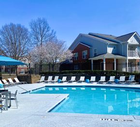 Atlanta apartment for rent - A swimming pool in front of a house with a fence and trees in the background.