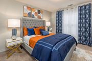 Atlanta apartment for rent - A bedroom with a large bed and a nightstand with a clock on it.