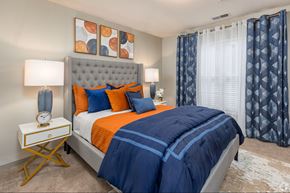 Atlanta apartment for rent - A bedroom with a large bed and a nightstand with a clock on it.