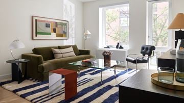 Bronx apartment for rent - A living room with a green couch, a coffee table, and a painting on the wall.