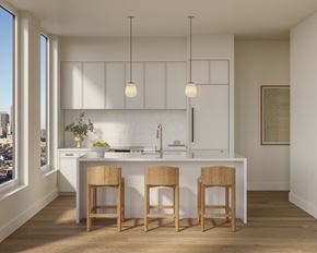 Brooklyn apartment for rent - A kitchen with white cabinets and a white countertop with two wooden barstools.