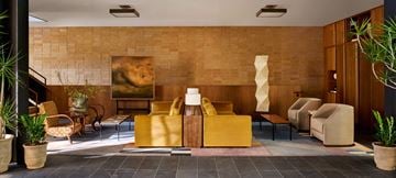 Long Island City apartment for rent - A living room with a yellow sofa and a painting on the wall.