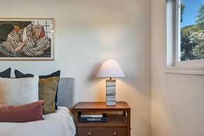 Belmont apartment for rent - A bedroom with a bed, a nightstand with a lamp and a painting on the wall.