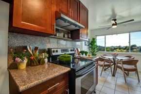 Belmont apartment for rent - A kitchen with a stove top oven and a fan.