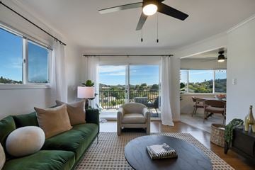 Belmont apartment for rent - A living room with a green couch and a ceiling fan.