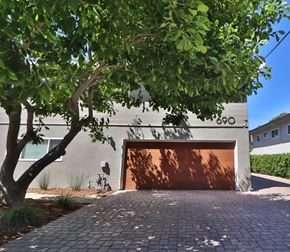 Menlo Park apartment for rent - A tree is in front of a house with a garage door.