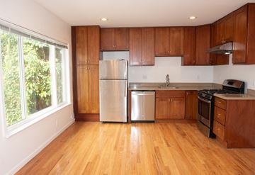 San Jose apartment for rent - A kitchen with wooden cabinets and a stainless steel refrigerator.