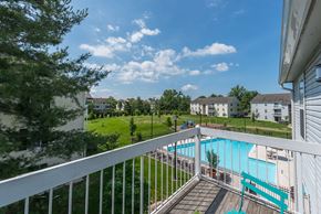 Alexandria apartment for rent - A view from a balcony overlooking a pool and apartment buildings.