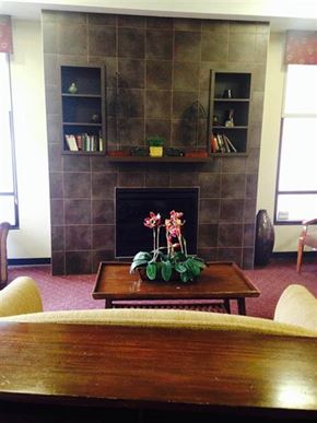 Baltimore apartment for rent - A room with a fireplace and a table in front of it.