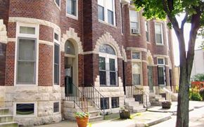 Baltimore apartment for rent - A red brick building with a black iron railing on the steps.