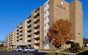 Arlington apartment for rent - Spectrum apartment building with cars parked in front.