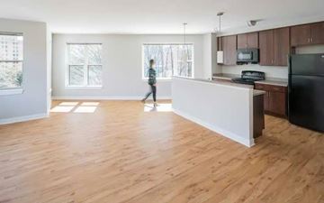 Alexandria apartment for rent - A person is walking in a spacious kitchen with wooden floors and white walls.