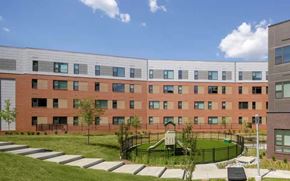 Alexandria apartment for rent - A large red brick building with a playground in front.