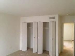 Falls Church apartment for rent - Three white closet doors are open in a room.