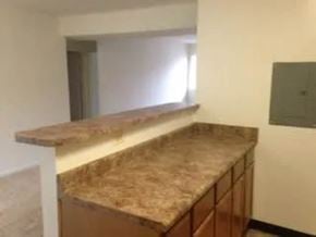 Falls Church apartment for rent - A kitchen counter with a marble top and wooden cabinets.