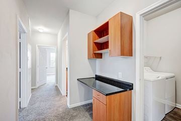 Germantown apartment for rent - A small kitchen with a black counter top and wooden cabinets.