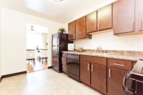 Arlington apartment for rent - A kitchen with brown cabinets and a black refrigerator.