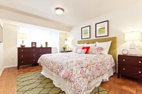 Arlington apartment for rent - A bedroom with a floral bedspread and a green headboard.