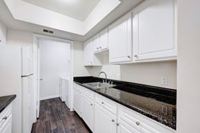 Gaithersburg apartment for rent - A kitchen with white cabinets and a black counter top.