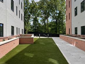 Arlington apartment for rent - A grassy courtyard is surrounded by two buildings.
