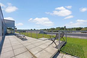 Arlington apartment for rent - A patio with a bench and a table is surrounded by a fence.