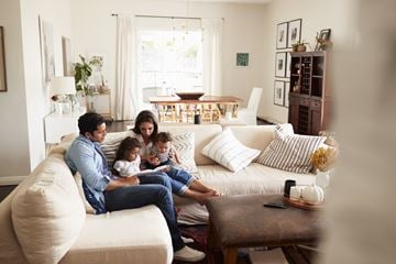 Fort Belvoir apartment for rent - A family of four is sitting on a couch in a living room.