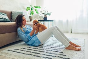 Silver Spring apartment for rent - A woman in a blue shirt is sitting on a rug with her orange cat.