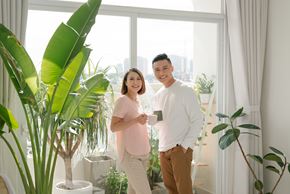 Arlington apartment for rent - A man and woman standing in a room with a large window and plants.