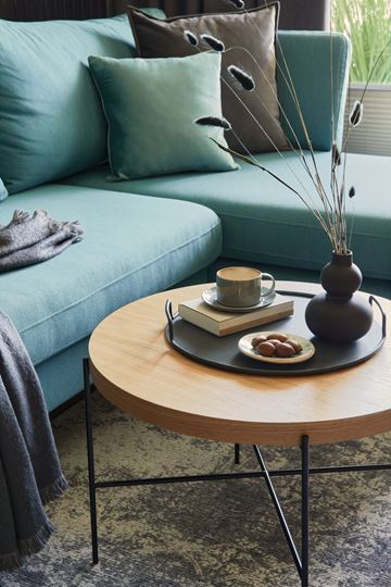 Arlington apartment for rent - A living room with a blue couch and a wooden coffee table with a vase, book, and cup on it.