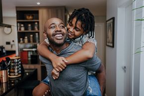 Alexandria apartment for rent - A man is giving a piggyback ride to a young girl in a kitchen.